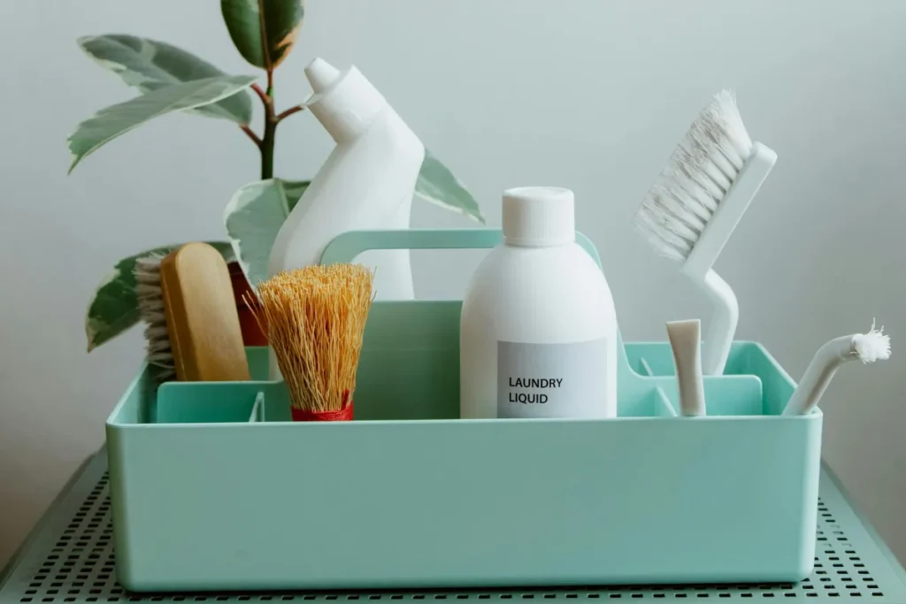 Organized laundry cleaning tools in a storage caddy on a shelf