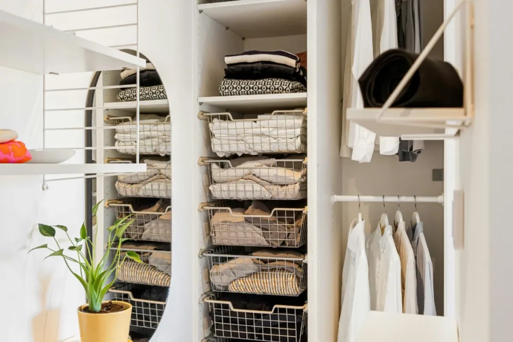 Small closet with baskets, shelves, and grouped clothing