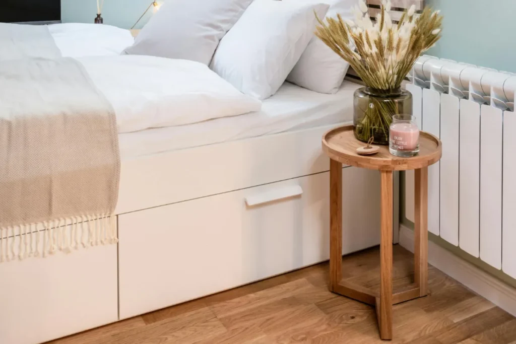 Small bedroom with under-bed storage drawers beside a tidy nightstand