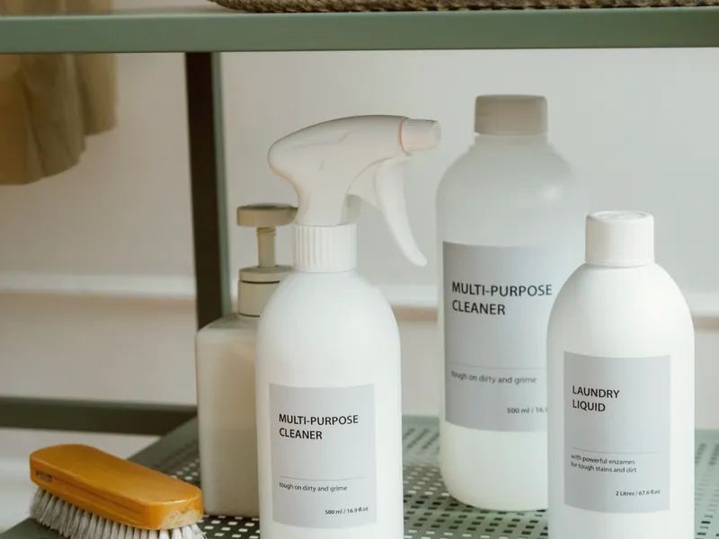 Neutral cleaning supplies and brush arranged on a shelf