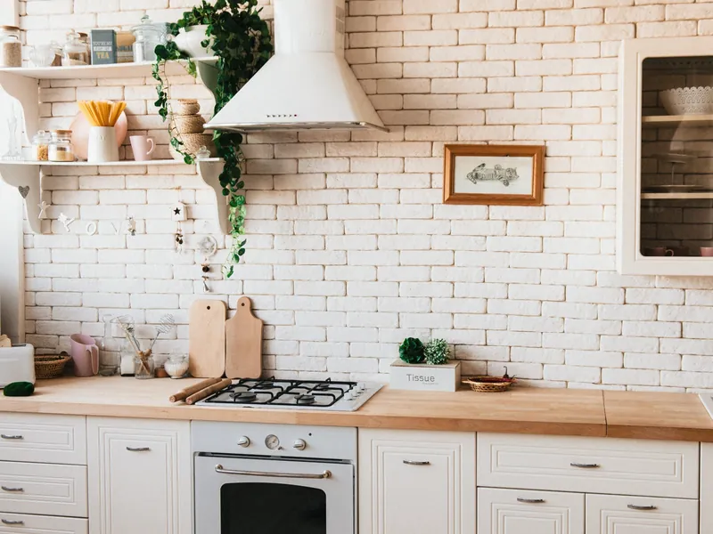 Bright cozy kitchen with stove, range hood, and wooden countertops