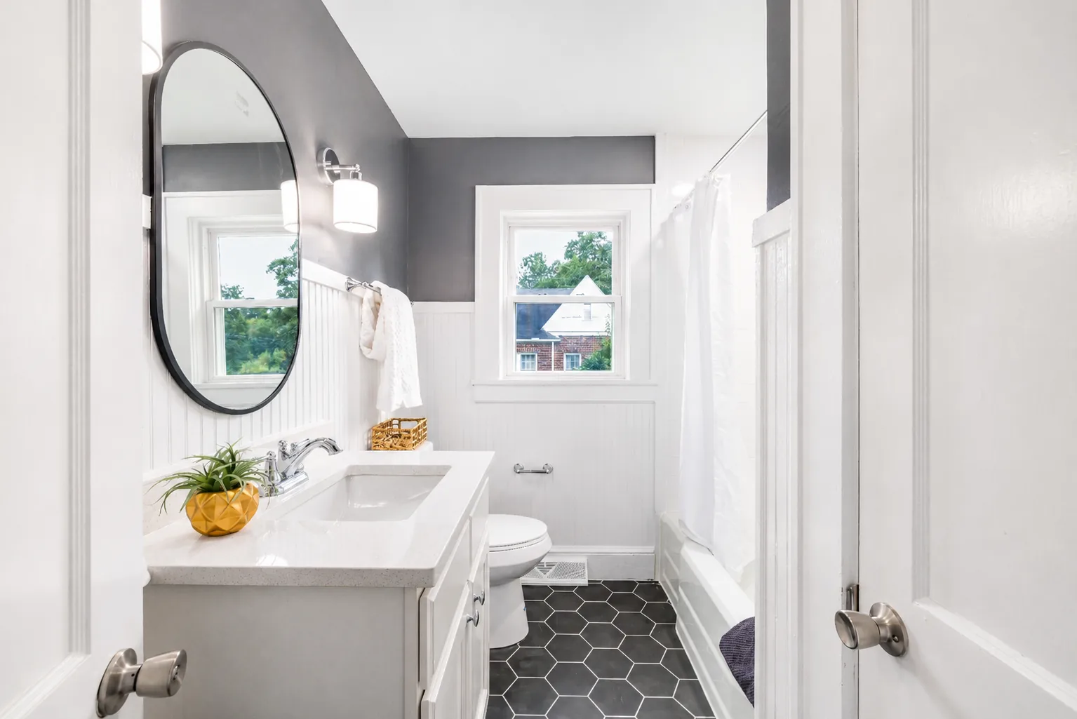 bright bathroom with shower, vanity, mirror, and natural light