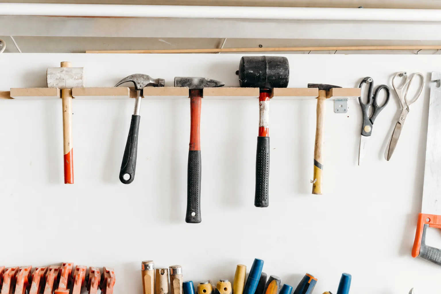 organized home repair tools hanging on a bright workshop wall