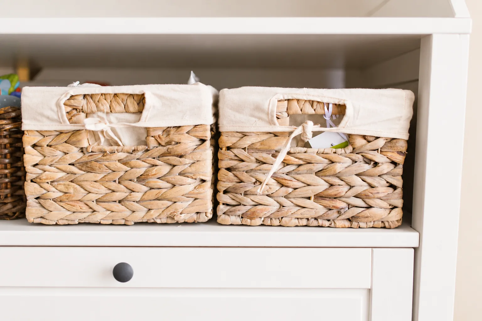 woven storage baskets neatly organized on a white shelf
