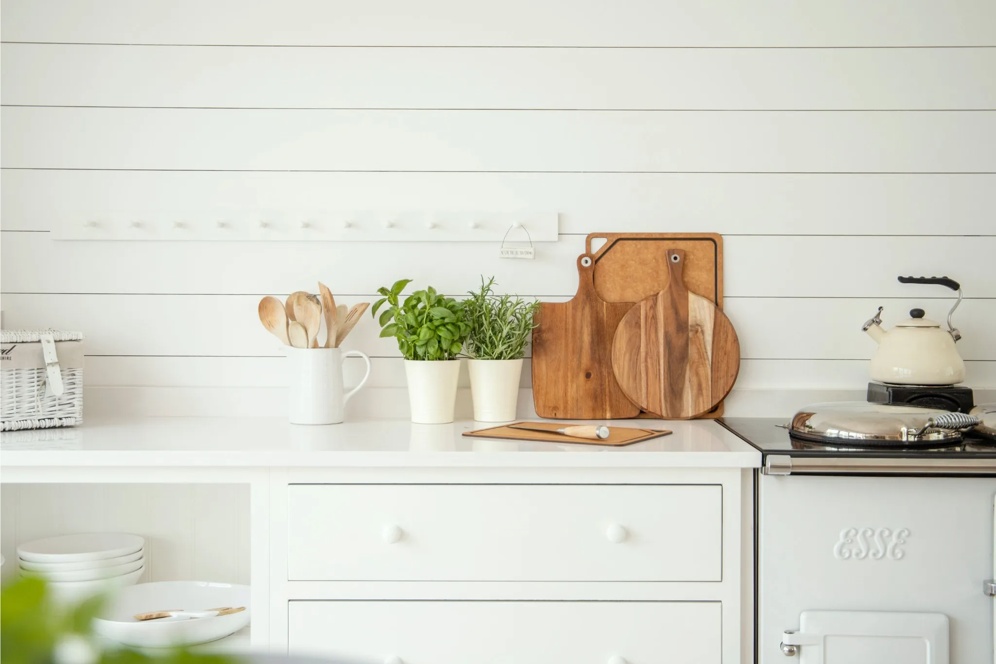 bright kitchen counter with cutting boards, herbs, and cooking utensils